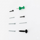 Set of screws and a green thumbtack on a white background